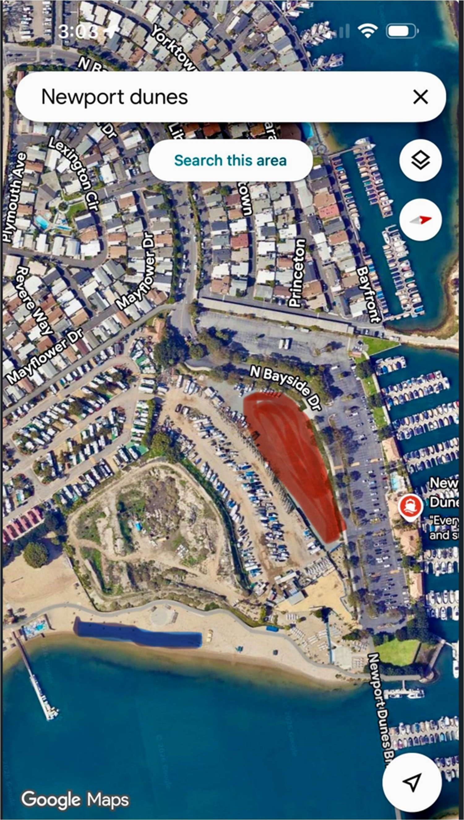 Aerial map of Newport Dunes with the gravel parking lot shaded red off North Bayside Drive, and the group tent sites shaded blue along the beach